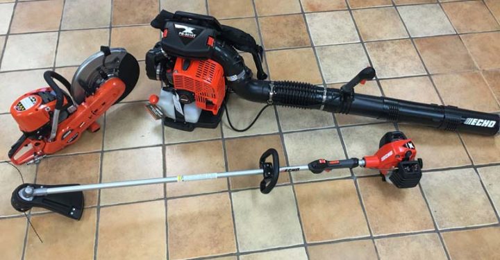 a blower, chainsaw and grass cutter on the floor